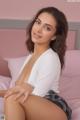 A woman sitting on top of a pink bed.