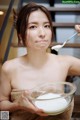 A woman holding a bowl of whipped cream and a spoon.