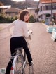 A woman riding a bike down a dirt road.