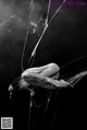 A black and white photo of a woman in a spider web.