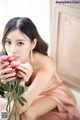 A woman in a pink dress holding a bunch of flowers.