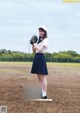 A woman in a baseball uniform holding a baseball glove.