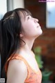 A woman with long black hair looking up at the sky.