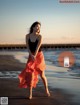 A woman walking on a beach near the ocean.