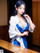 A woman in a blue and white kimono standing at a bar.