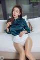 A woman sitting on top of a white couch.