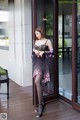 A woman in lingerie standing in front of a glass door.