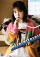 A young girl sitting on a bed holding a keyboard.