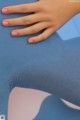 A close up of a woman's hand on a blue chair.